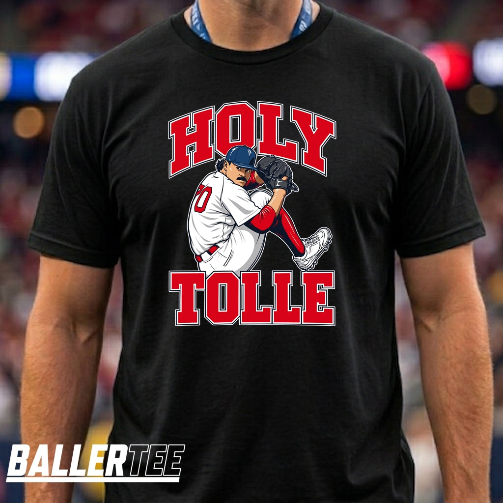 A man wearing a black t-shirt with a graphic of a baseball player and the text 'HOLY TOLLE' in red and white. The brand logo 'BALLERTEE' is visible in the bottom-left corner.