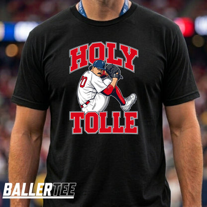 A man wearing a black t-shirt with a graphic of a baseball player and the text 'HOLY TOLLE' in red and white. The brand logo 'BALLERTEE' is visible in the bottom-left corner.