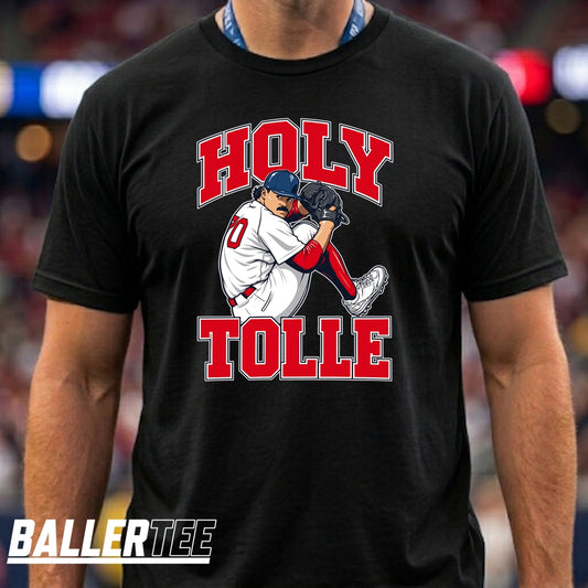 A man wearing a black t-shirt with a graphic of a baseball player and the text 'HOLY TOLLE' in red and white. The brand logo 'BALLERTEE' is visible in the bottom-left corner.