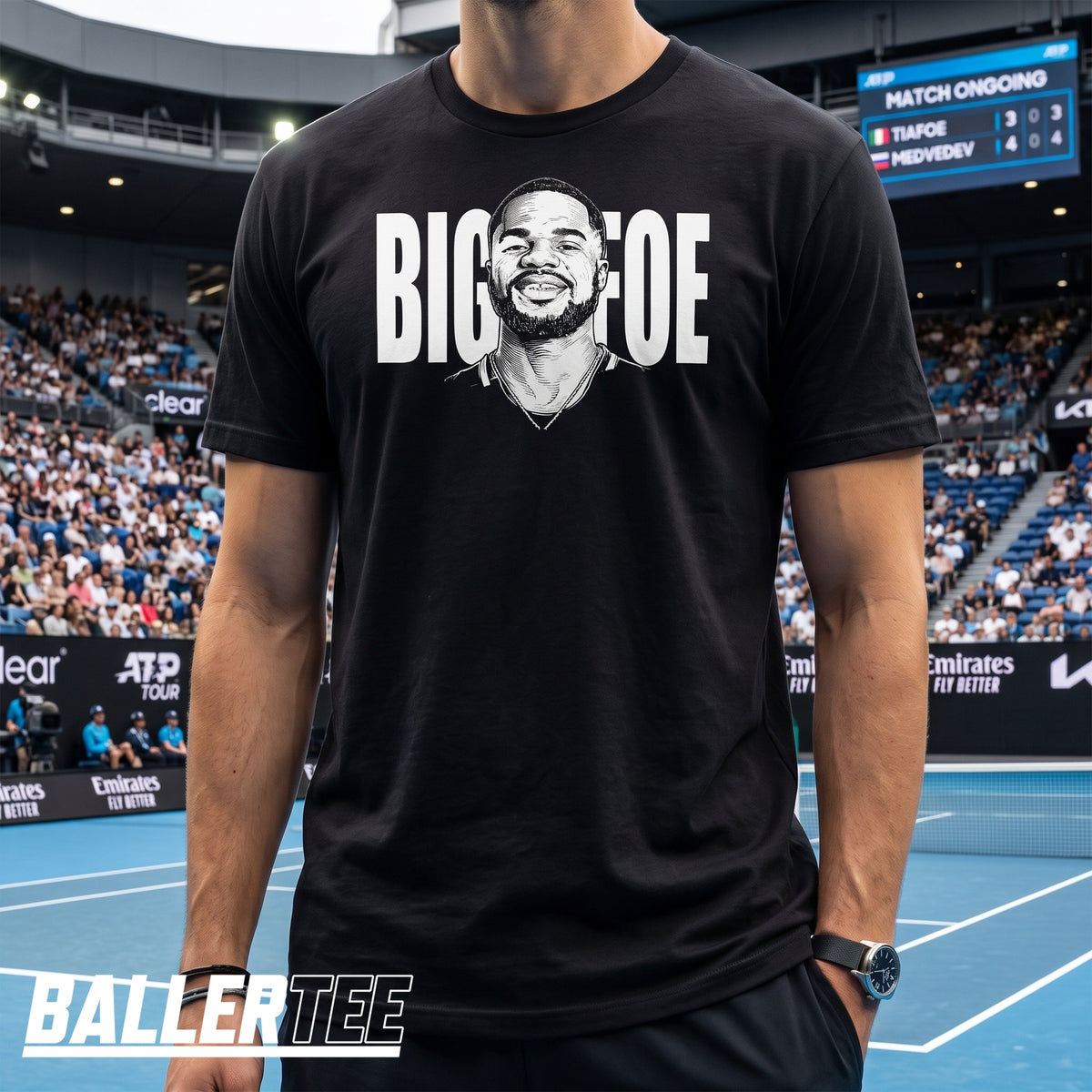 A man wearing a black graphic t-shirt with a white print of a tennis player's face and the text 'BIG GAME' in a stadium setting.