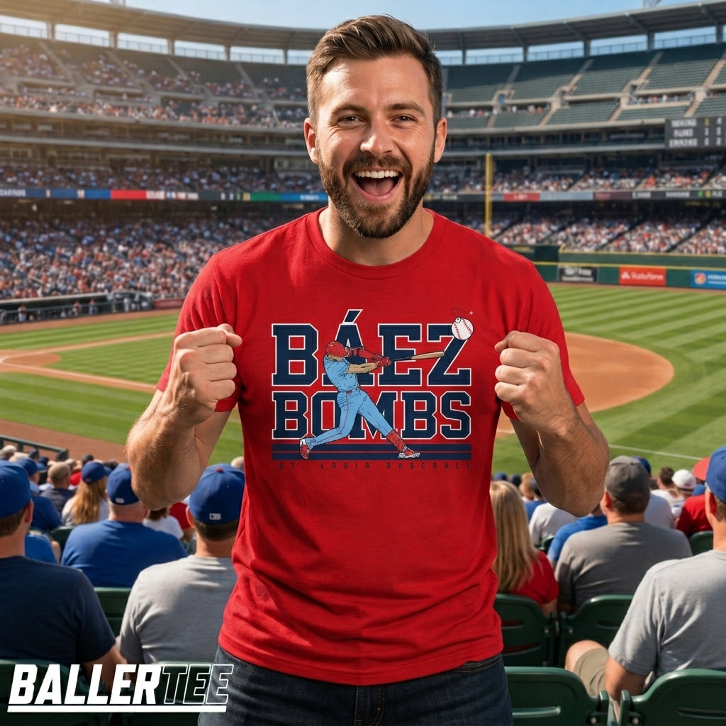 A man in a red baseball stadium wearing a red graphic t-shirt that says 'BÉEZ BOMBS' with a blue baseball player graphic. The background shows a packed baseball stadium.
