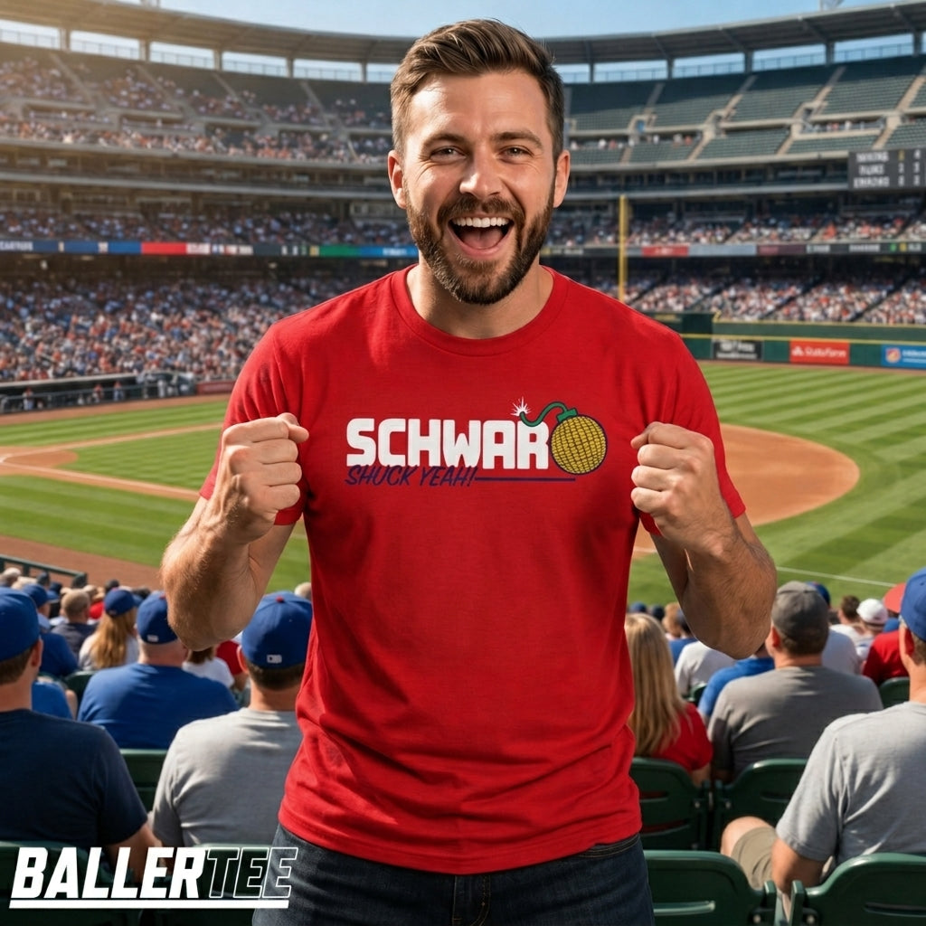 A man wearing a red graphic t-shirt with 'SCHWARZ since 1994' and a tennis ball graphic, standing in a crowded baseball stadium. The BallerTee logo is visible in the bottom-left corner.